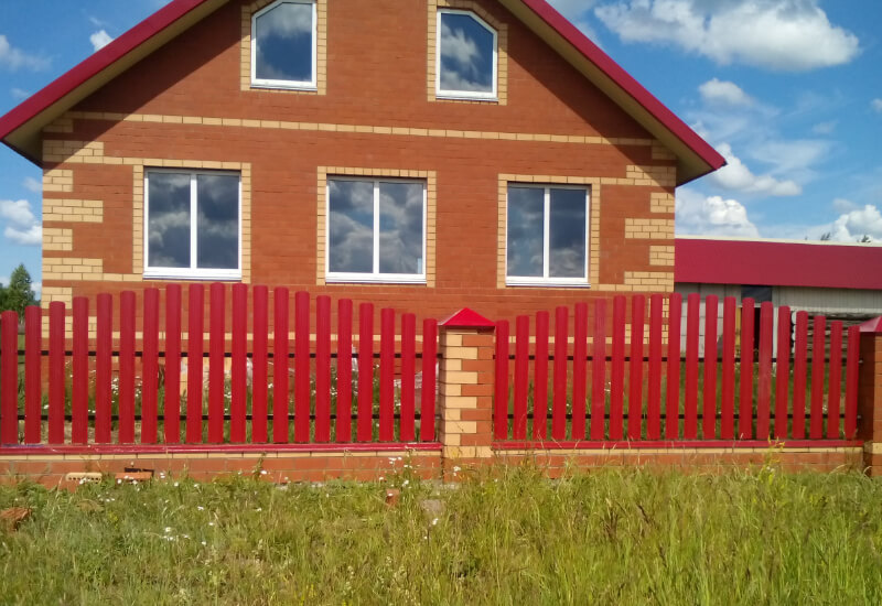 Забор из металлоштакетника цвета рубин с кирпичными столбами в Уральске фото 2